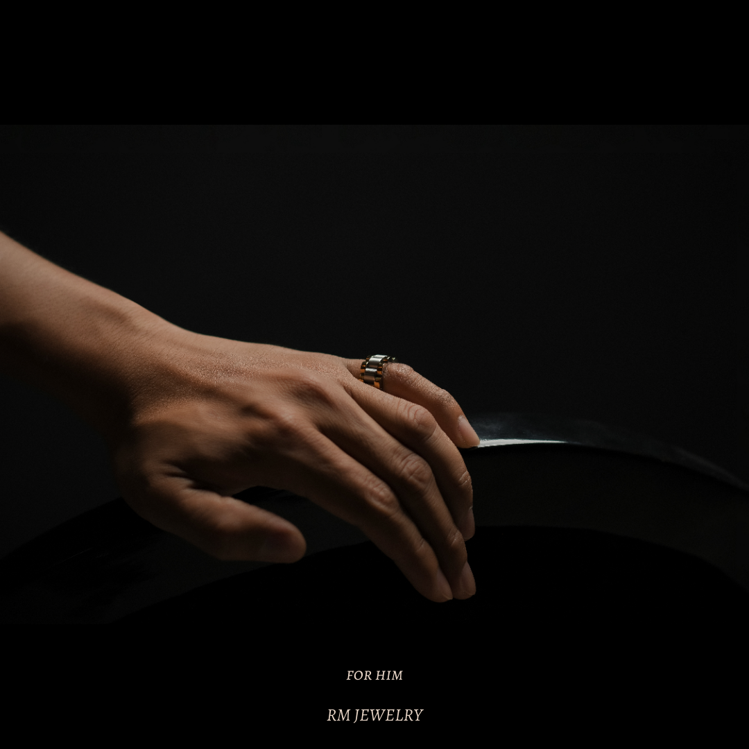 Hand wearing a bold men’s ring by RM Jewelry, photographed in low light to emphasize strength and elegance.