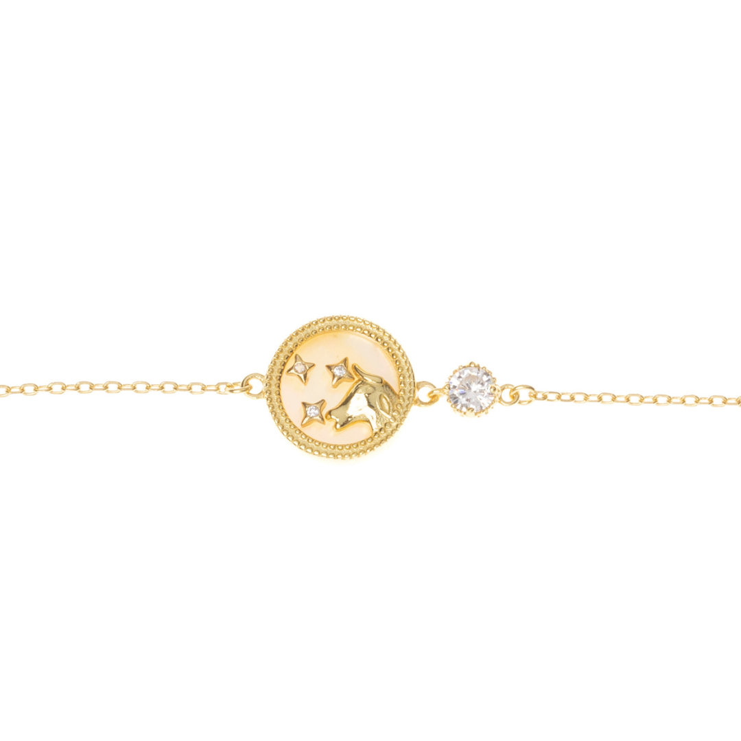 Taurus zodiac bracelet in gold-finished sterling silver, laid on white background with strong Taurus artwork